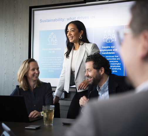 Three RGF Staffing colleagues discussing something in an office meeting room